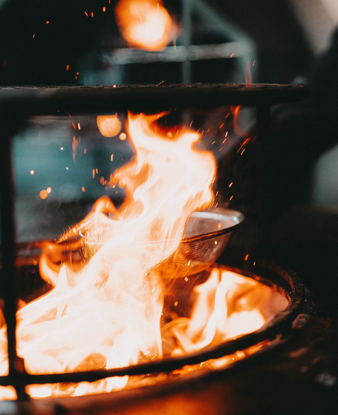 Pitmaster bereitet Speisen am offenen Feuer bei Alpenglut zu